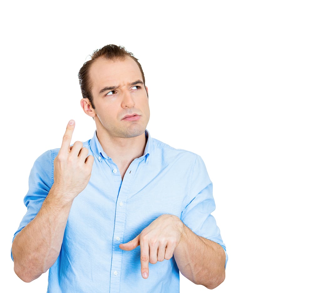 Closeup portrait confused young business man pointing in two different directions, not sure which way to go life, hesitant to make decision isolate white background. Emotion, facial expression feeling